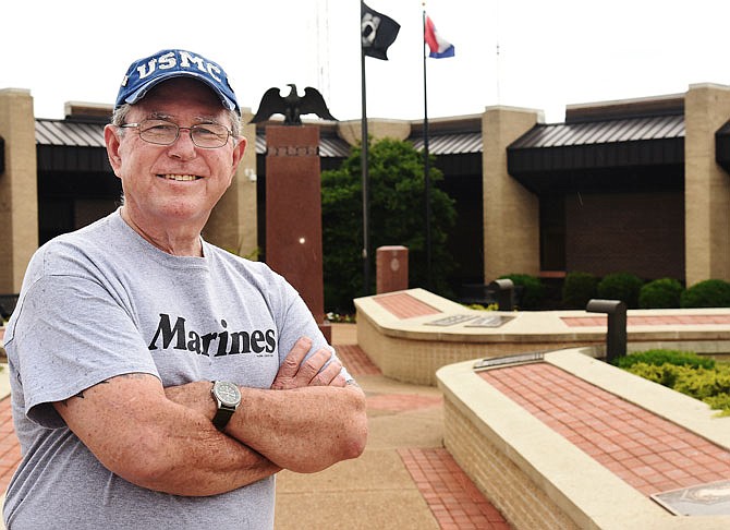 Hal Dulle poses in Veterans Plaza located in front of the Jefferson City Police Department. The committee that oversees maintenance of the memorial wants to modify the current cases so as to fit more bricks and to get the ones on the ground raised to the cases. 