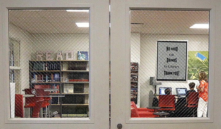 In this May 8, 2019, photo, the Stidham family does homework in the library of the East Webster High School, in Maben, Miss. The Stidhams are unable to get internet at their home in the county, so they take advantage of the internet in the school's library to work on their homework. (AP Photo/Rogelio V. Solis)