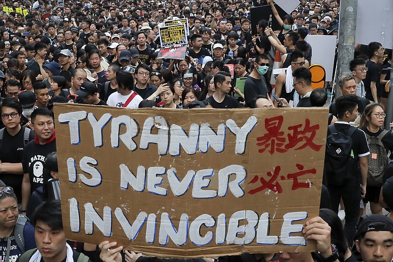 Tens of thousands of protesters carry posters and banners march through the streets as they continue to protest an extradition bill, Sunday, June 16, 2019, in Hong Kong. Hong Kong residents were gathering Sunday for another mass protest over an unpopular extradition bill that has highlighted the territory's apprehension about relations with mainland China. (AP Photo/Kin Cheung)