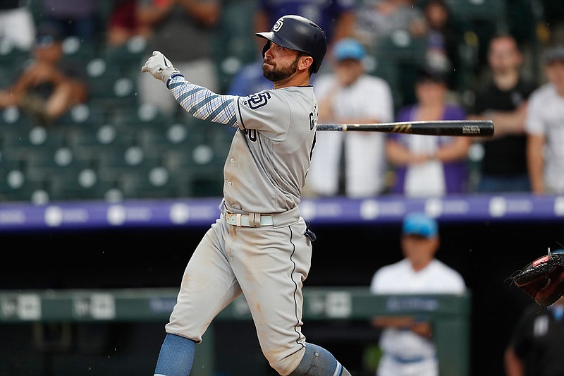 San Diego Padres' Greg Garcia follows the flight of his triple to drive in two runs off Colorado Rockies relief pitcher Wade Davis in the ninth inning Sunday in Denver.