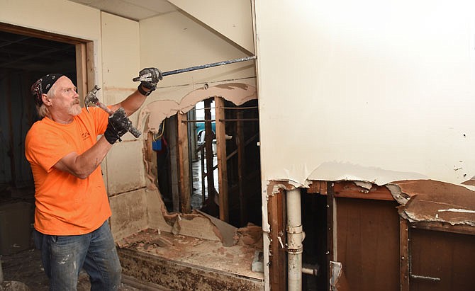 The water in and around the Jefferson City Memorial Airport has receded just enough to allow workers in the office and hangars of Jefferson City Flying Service to begin cleanup after the flood. Gary Baitinger, of JCFS, uses a hammer and crowbar Monday to remove drywall from office space in their building adjacent to the airport's tarmac. The muddy water of the Missouri River has left behind a brown residue on walls, cabinets and anything else within the 3-4 feet depth range.