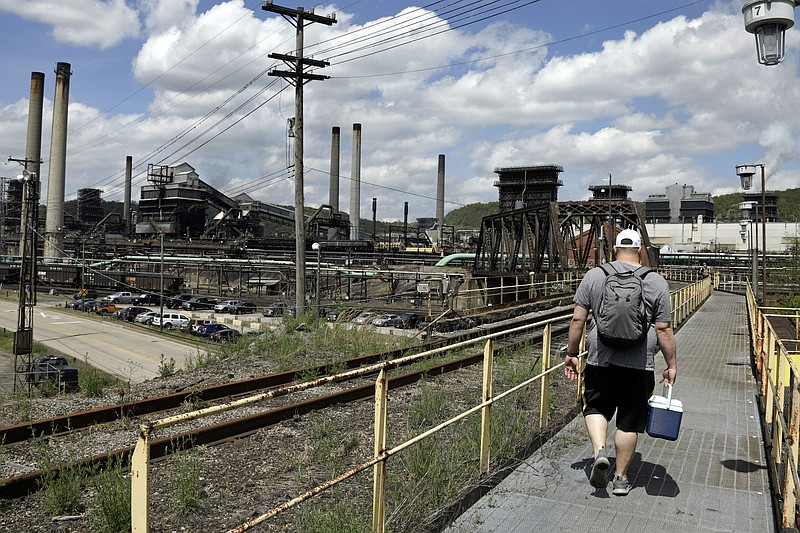 FILE - In this May 2, 2019, file photo a worker arrives for his shift at the U.S. Steel Clairton Coke Works in Clairton, Pa. A fire at U.S. Steel's massive coke plant outside Pittsburgh knocked a key pollution control system offline Monday, June 17, 2019. It triggered a health warning as officials monitored the air around the plant for signs of a release of toxic sulfur dioxide. It was the second fire since December at the coke works, the largest facility of its kind in the United States. The plant turns coal into coke, one of the raw materials of steel. (AP Photo/Gene J. Puskar, FILE)