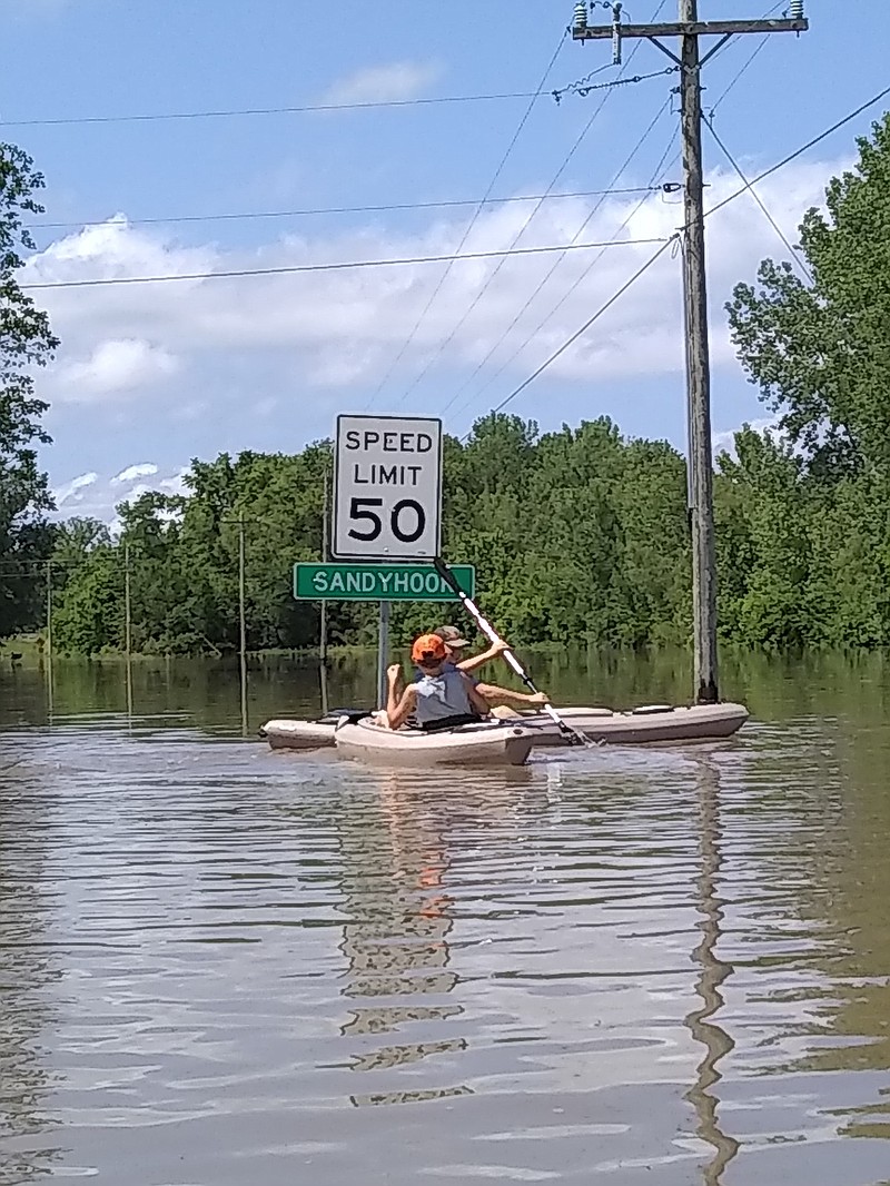 A Sandy Hook resident paddles near the speed marker on Missouri 179 in town. (Photo by Chanda Lusk)