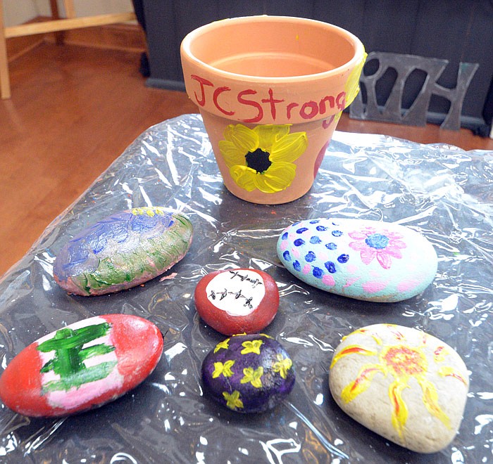 Painted rocks and flower pots display their messages of love and encouragement Tuesday, June 18, 2019, at Capital Arts in Jefferson City. 