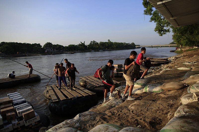 A group of migrants arriving from Guatemala disembark from a raft in Ciudad Hidalgo, Mexico, Tuesday, June 18, 2019. The number of migrants taking rafts at the busy Ciudad Hidalgo crossing point appears to have decreased significantly in recent days amid fears of a pending deployment of the National Guard along the southern border. (AP Photo/Rebecca Blackwell)