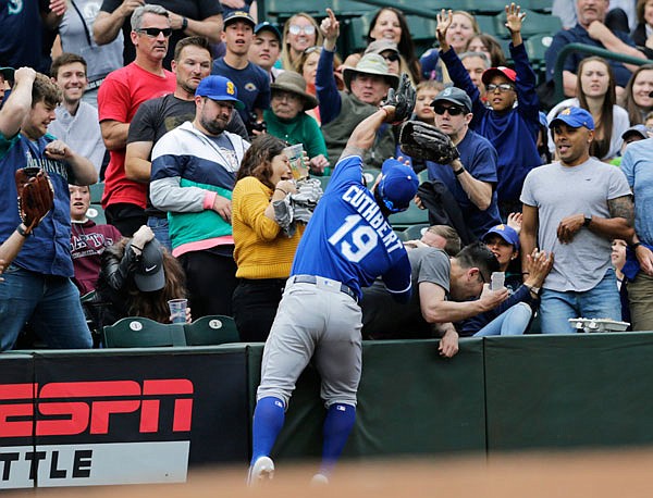 Royals third baseman Cheslor Cuthbert reaches into the stands to catch a ball hit by Kyle Seager of the Mariners for an out during the fourth inning of Wednesday's game in Seattle.