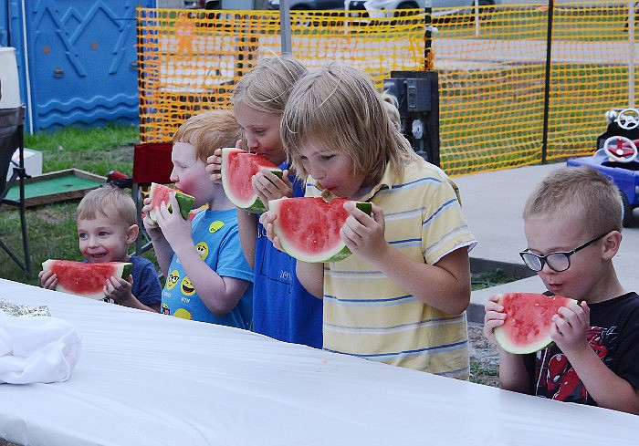 Children rush to take their first bite of watermelon during the watermelon eating contest at the annual Tebbetts Community Picnic in 2018. Each child received a prize after finishing.