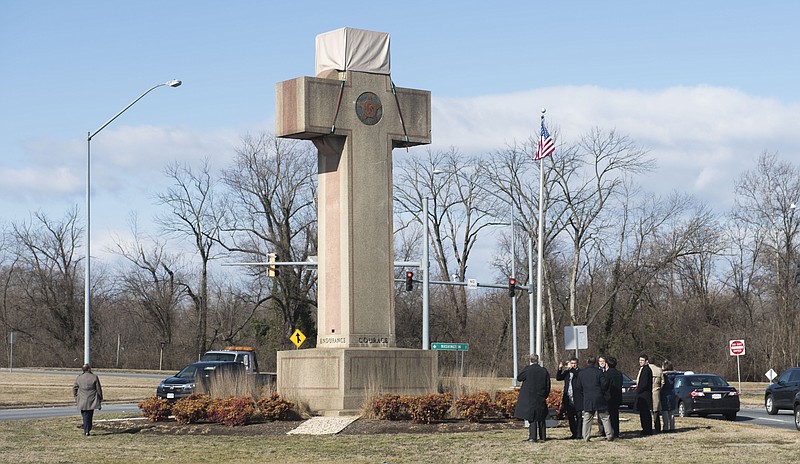 FILE - In this Feb. 13, 2019 file photo, visitors walk around the 40-foot Maryland Peace Cross dedicated to World War I soldiers in Bladensburg, Md. The Supreme Court says the World War I memorial in the shape of a 40-foot-tall cross can continue to stand on public land in Maryland. The high court on Thursday rejected a challenge to the nearly 100-year-old memorial. The justices ruled that its presence on public land doesn’t violate the First Amendment’s establishment clause. That clause prohibits the government from favoring one religion over others.(AP Photo/Kevin Wolf)