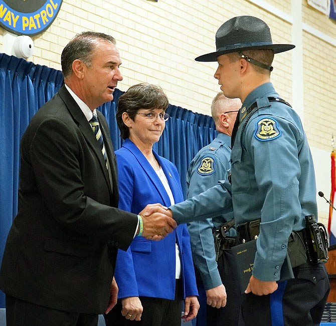 Lt. Gov. Mike Kehoe, left, offers congratulations and words of encouragement Friday to new trooper Luke Benke, of Jefferson City. Benke was one of 31 new Missouri Highway Patrol troopers sworn in Friday. Standing next to Kehoe is Sandra Karsten, director of the Department of Public Safety.