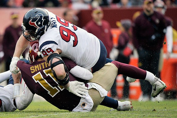 In this Nov. 18, 2018 file photo, Redskins quarterback Alex Smith injures his leg on a sack by Texans strong safety Kareem Jackson (left) and defensive end J.J. Watt during a game in Landover, Md.