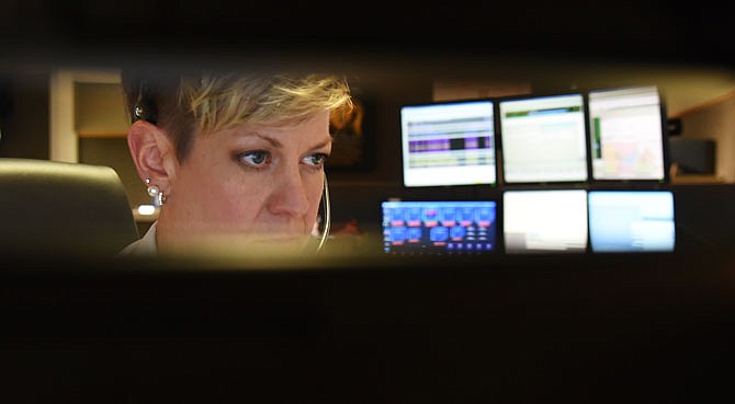 Jefferson City 911 Communications Supervisor Angie Stiefermann is seen between computer monitors Friday as she pays close attention to the information in front of her while on an emergency call. Stiefermann was on duty the night of the tornado and answered numerous calls about lines down, houses destroyed.