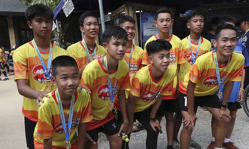 Members of the Wild Boars soccer team who were rescued from a flooded cave, pose for the media after a marathon and biking event in Mae Sai, Chiang Rai province, Thailand, Sunday, June 23, 2019. Some of the 12 young Thai soccer players and their coach have marked the anniversary of their ordeal that saw them trapped in a flooded cave for two weeks with a commemorative marathon in northern Thailand. (AP Photo/Sakchai Lalit)