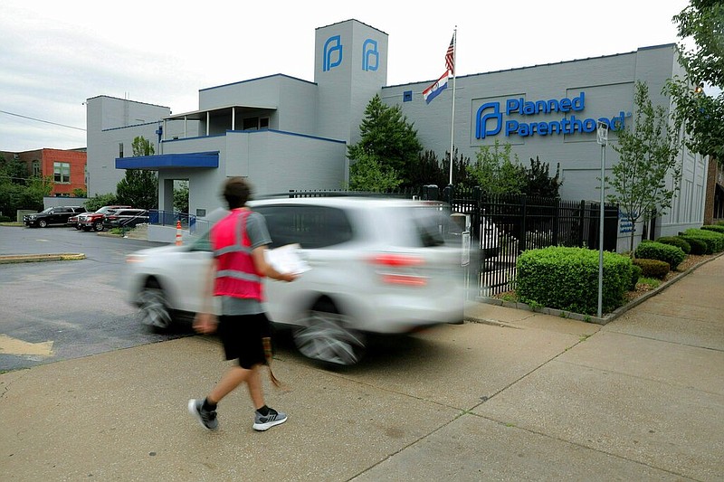 In this June 21, 2019 file photo, an anti-abortion advocate attempts to solicit a motorist entering the parking lot of the Planned Parenthood of the St. Louis Region and Southwest Missouri, the state's last operating abortion clinic in St. Louis. (Christian Gooden/St. Louis Post-Dispatch via AP File)