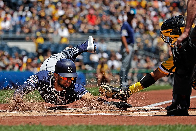 San Diego Padres' Fernando Tatis Jr., left, scores under a tag attempted by Pittsburgh Pirates catcher Elias Diaz, right rear, on Sunday in Pittsburgh. Tatis tagged up at third on a sacrifice fly to second by Hunter Renfroe.