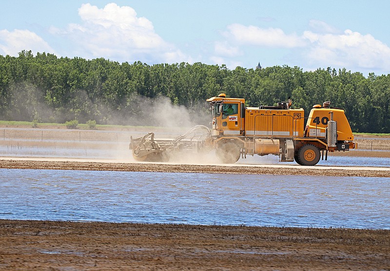 A snow broom truck removes dirt and mud Monday from the taxiway at the Jefferson City Memorial Airport. City of Jefferson Public Works Operations Division Director Britt Smith said he hopes the airport can be open again for flights later this week.
