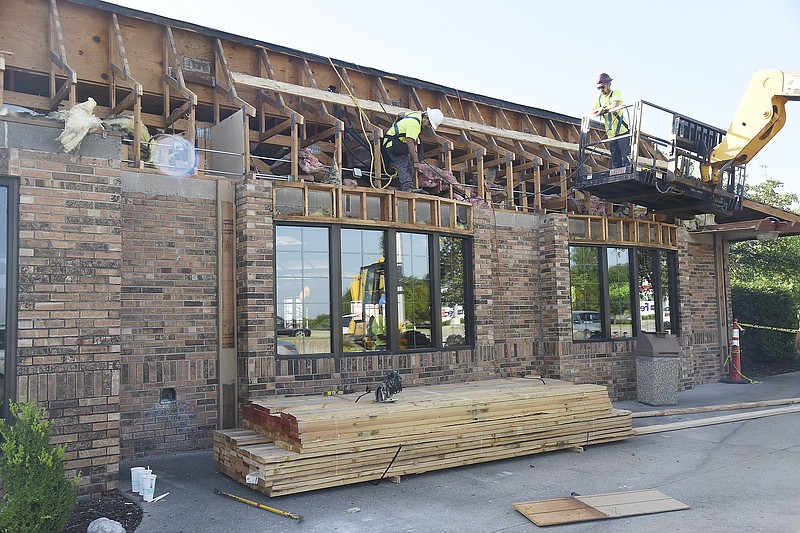 Julie Smith/News Tribune
 Axel Gomez, left, and Marcus Voss, both of JE Hefner Construction in Kansas City, work on the exterior of the McDonald's Restaurant on Eastland Drive Friday morning. McDonald's will be undergoing renovation and updating on the building over the upcoming weeks. 