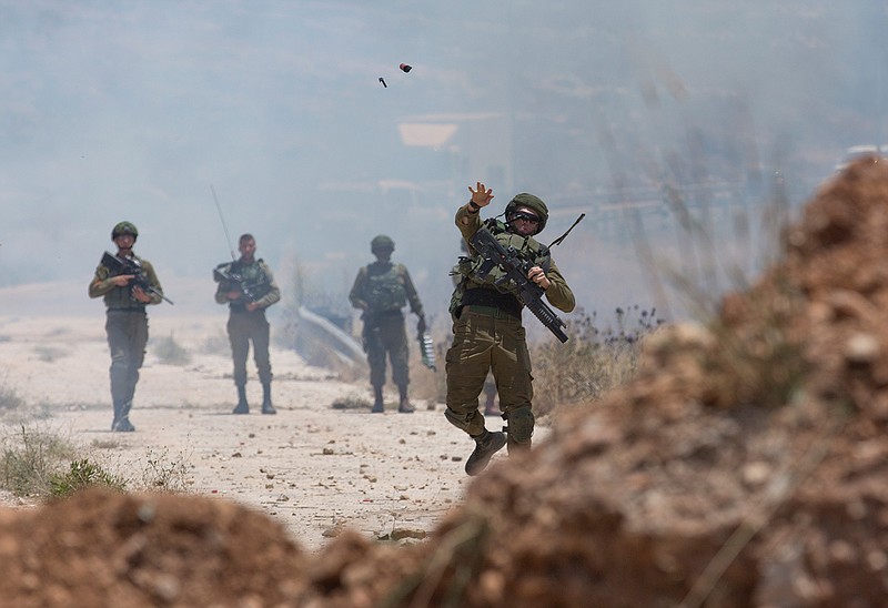 Israeli border police use teargas to disperse Palestinian protesters during a rally against the American-led Mideast peace conference, near the settlement of Beit El, at the outskirts of the West Bank city of Ramallah Tuesday, June. 25, 2019. (AP Photo/Nasser Nasser)
