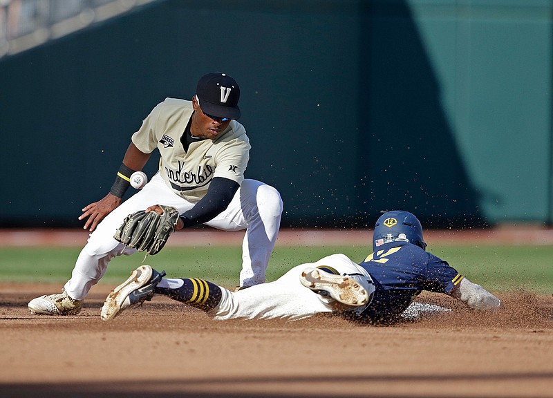 Michigan's Riley Bertram, right, steals second base as Vanderbilt's Harrison Ray, left, misses the tag during the second inning in Game 3 of the NCAA College World Series baseball finals in Omaha, Neb., Wednesday, June 26, 2019. (AP Photo/Nati Harnik)