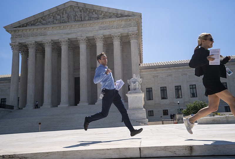 News agency interns sprint across the plaza at the Supreme Court with copies of the justices' final decisions of the term, in Washington, Thursday, June 27, 2019. The final day brought key decisions on gerrymandering and a census case involving an attempt by the Trump administration to ask everyone about their citizenship status in the 2020 census. (AP Photo/J. Scott Applewhite)