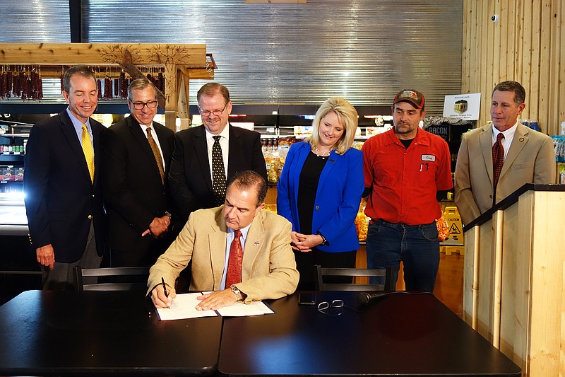 Lt. Gov. Mike Kehoe signs an executive order establishing the Missouri
Food, Beverage and Forest Products Manufacturing Task Force at Central Missouri Meat and Sausage in Fulton on Friday, June 28, 2019. Marshall Stewart, left, chief engagement officer for the University of Missouri; Chris Daubert, vice chancellor of agriculture at MU; MU Chancellor Alexander Cartwright, Chris Chinn (director of the MIssouri Department of Agriculture); Cory Hawkins, part-owner of CMMS; and Dan Cassidy, chief administrative officer for the Missouri Farm Bureau, look on.                              