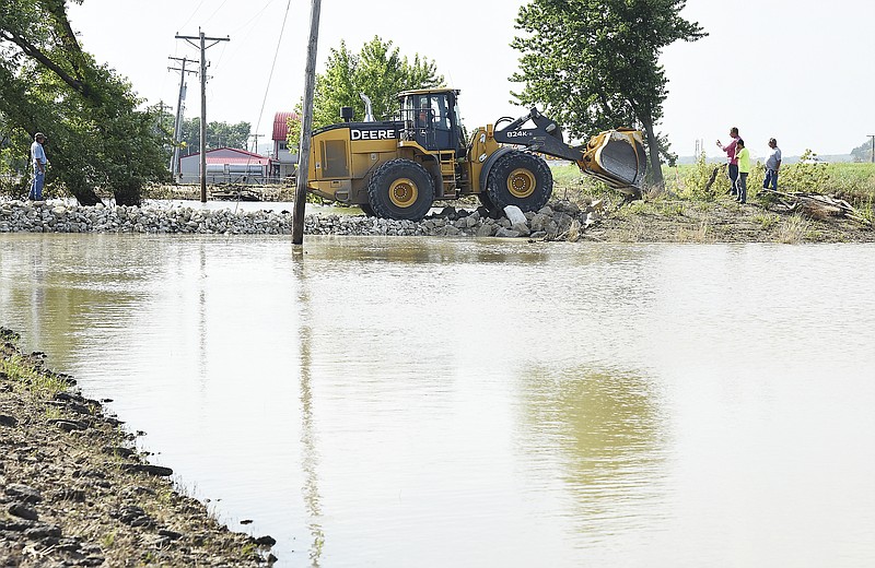 In a cooperative effort between Jefferson City Public Works, MoDOT and Capital Sand Company, the levee breach at Turkey Creek near the Route W bridge was filled in a matter of hours Thursday. Capital Sand provided a heavy duty front end loader to move the boulders brought in by MoDOT and Jefferson City Public Works dump trucks used to fill in the break in the levee. After several loads of various sizes of rocks were emptied and moved in to form a barrier, officials believed they were in a good position to hold back the water until it begins to recede. 