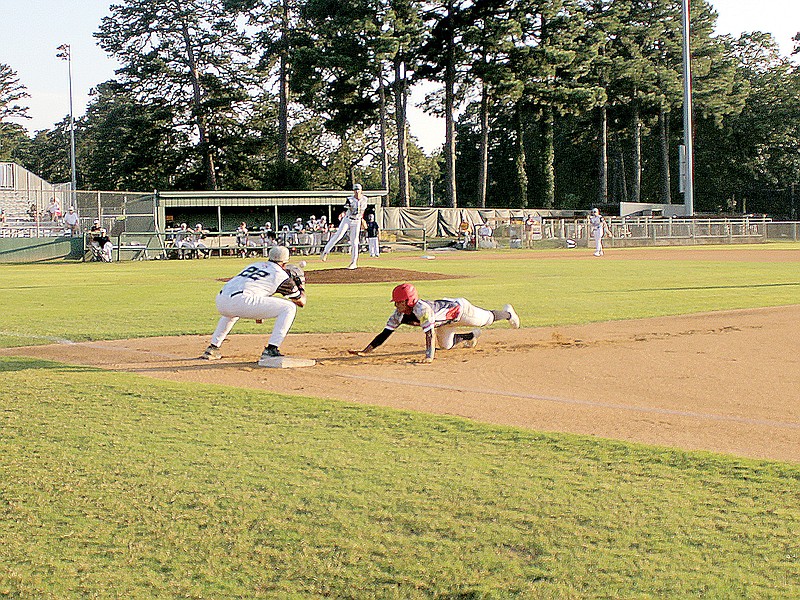 U.S. Military's Steven Mendoza slides safely to first after Texarkana Twins pitcher Brock Booker's attempted pickoff on Thursday at George Dobson Field at Spring Lake Park in Texarkana, Texas. See complete game coverage in Saturday's edition.