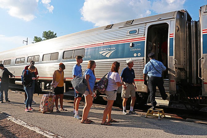 A group of passengers load onto the Missouri River Runner Amtrak train to Kansas City on Tuesday evening. The trains had not been running over the last several days due to high floodwaters but opened up again Monday.