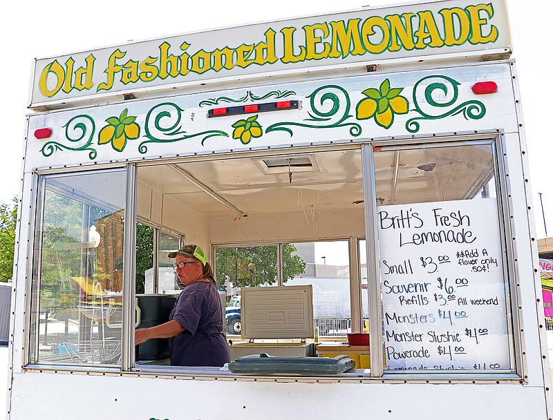 Stacy Bame with Southern Fun Carnival Company cleans out coolers Tuesday in the Old Fashioned Lemonade stand. Salute to America's Carnival Land will be open 4-11 p.m. today and 11 a.m.-10 p.m. Thursday.