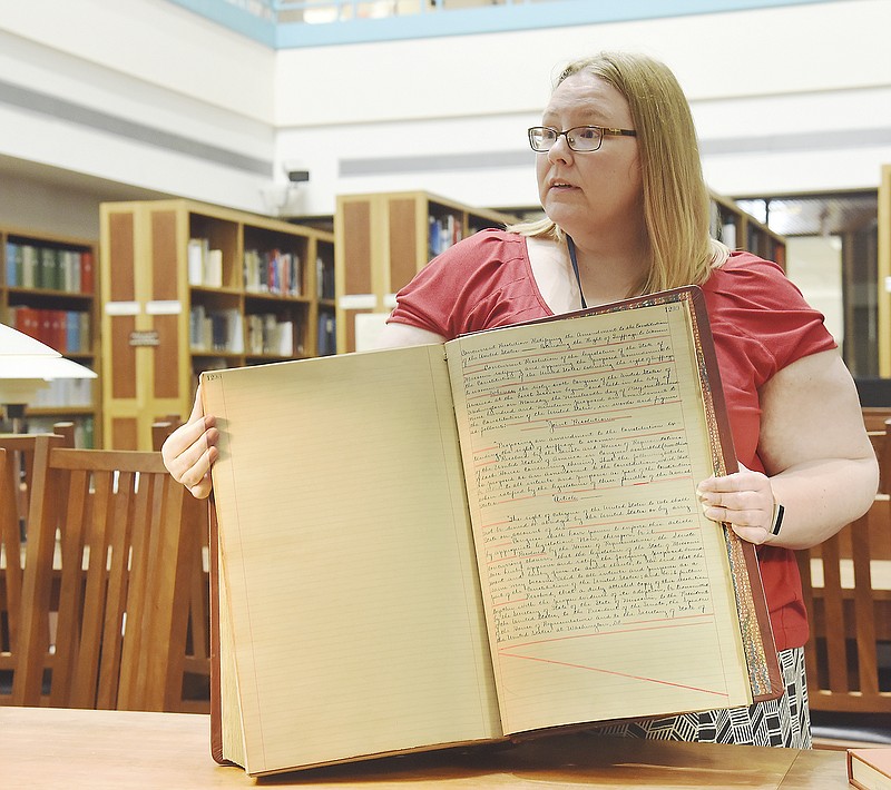 Christina Miller, senior reference archivist, holds the oversized, bound book that contains handwritten details regarding legislation securing a women's right to vote. Today marks the 100th anniversary of Missouri's ratification of what eventually became known as the 19th amendment or the women's right to vote.