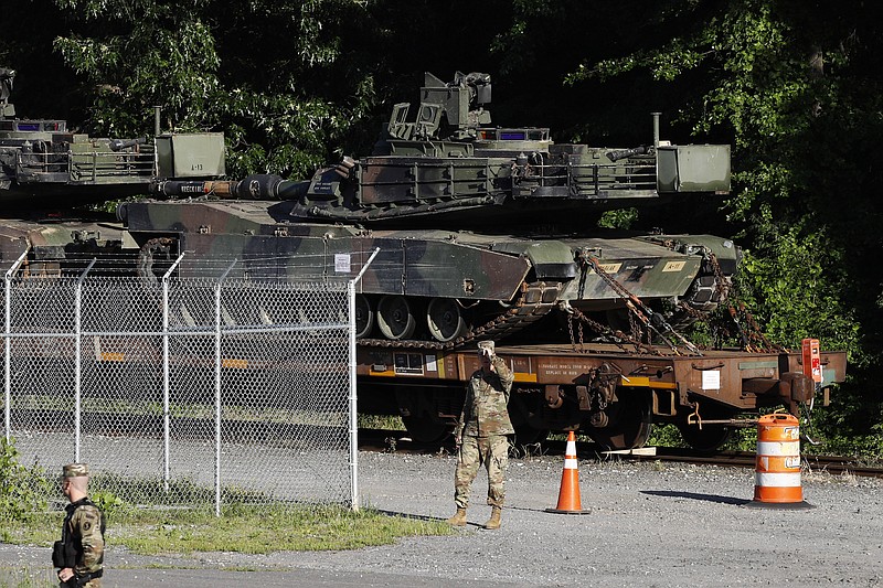 Military police walk near Abrams tanks on a flat car in a rail yard, Monday, July 1, 2019, in Washington, ahead of a Fourth of July celebration that President Donald Trump says will include military hardware. (AP Photo/Patrick Semansky)