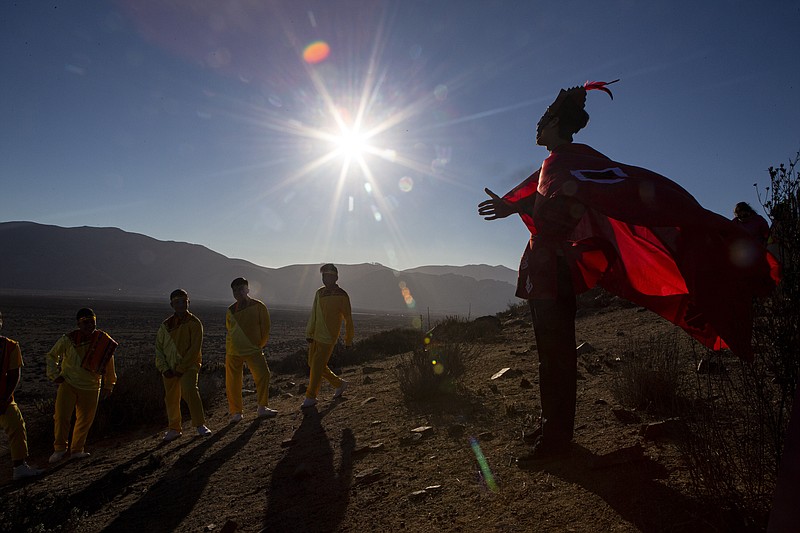 A youth dressed as a shaman arrives to take part in a photo session before Tuesday's total solar eclipse, in La Higuera, Chile, Monday, July 1, 2019. Tourists and scientists will gather in northern Chile, one of the best places in the world to watch the next the eclipse that will plunge parts of South America into darkness. (AP Photo/Esteban Felix)