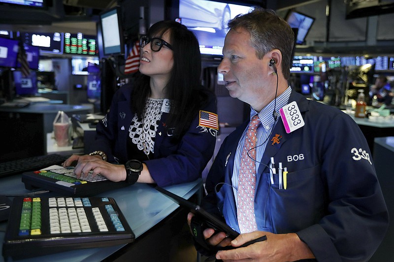 FILE - In this July 1, 2019, file photo specialist Erica Fredricks and trader Robert Charmak work on on the floor of the New York Stock Exchange. The U.S. stock market opens at 9:30 a.m. EDT on Tuesday, July 2. (AP Photo/Richard Drew, File)