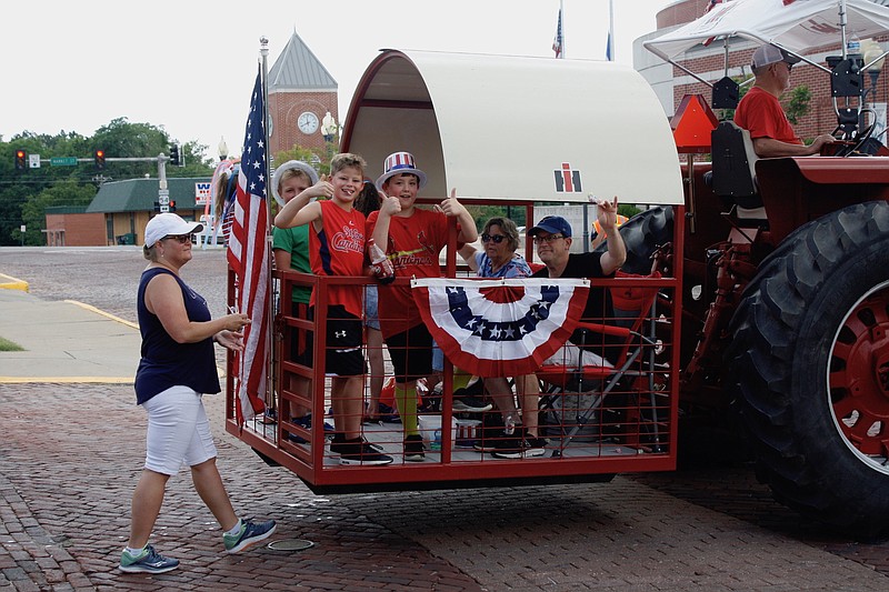 <p>Quinn Wilson/FULTON SUN</p><p>Participants during the eighth annual Independence Day Parade of Callaway County smile and wave on board their tractor float.</p>