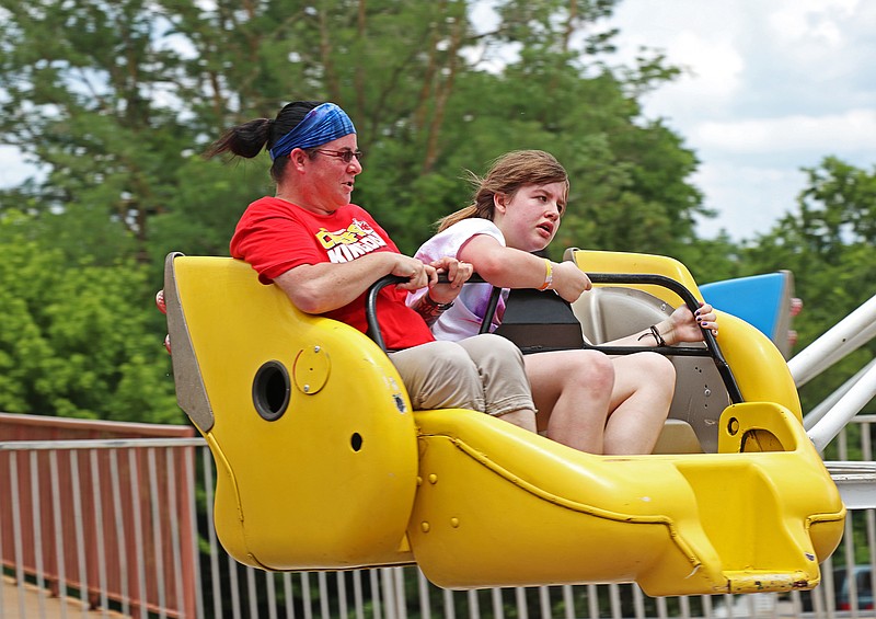 Greta Cross / News Tribune
From left, Charise Widener and Rebekka Widener, 12, are slung against the outside of their seat on the Sizzler during the Salute to America Celebration Thursday.