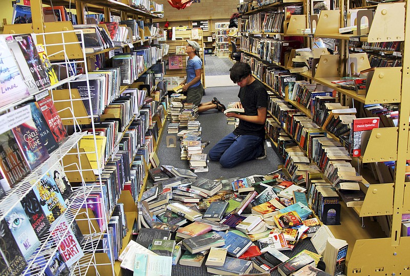 Volunteers assist with cleanup at the Ridgecrest, Calif., branch of the Kern County Library on Friday, July 5, 2019, following a 6.4 magnitude earthquake that shook the region about 150 miles (240 kilometers) northeast of Los Angeles Thursday. Aftershocks from Southern California's largest earthquake in 20 years rumbled beneath the Mojave Desert on Friday as authorities tallied damage in the sparsely populated region. (Jessica Weston/The Daily Independent via AP)