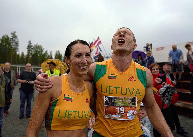 Lithuanian couple Vytautas Kirkliauskas, right, and Neringa Kirkliauskiene celebrate their victory in the wife carrying race, a 278-yard obstacle course, during the 24th world championships in Sonkajarvi, Finland, Saturday, July 6, 2019. Despite the event's name couples don't have to be married, and organizers say male contestants could "steal a neighbor's wife" if they didn't have a female companion. (AP Photo/David Keyton)