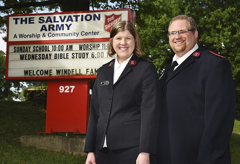Sarah and Justin Windell, new captains at The Salvation Army Center of Hope, pose in front of The Salvation Army's sign. The Windell's arrived during the latter part of June