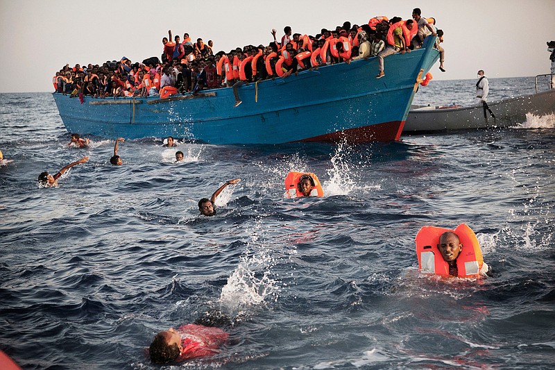 In this Monday, Aug. 29, 2016 file photo, migrants, most of them from Eritrea, jump into the water from a crowded wooden boat as they are helped by members of an NGO during a rescue operation at the Mediterranean sea, about 13 miles north of Sabratha, Libya. On Friday, July 5, 2019, Libya's interior minister, Fathi Bashagha, pleaded Friday for Europe "to address the problem in a radical way _ not to prevent migrants, but to provide jobs and investment in the migrants' places of origin, as well as in southern Libya ... so as to absorb these huge numbers willing and eager to migrate to Europe." (AP Photo/Emilio Morenatti)