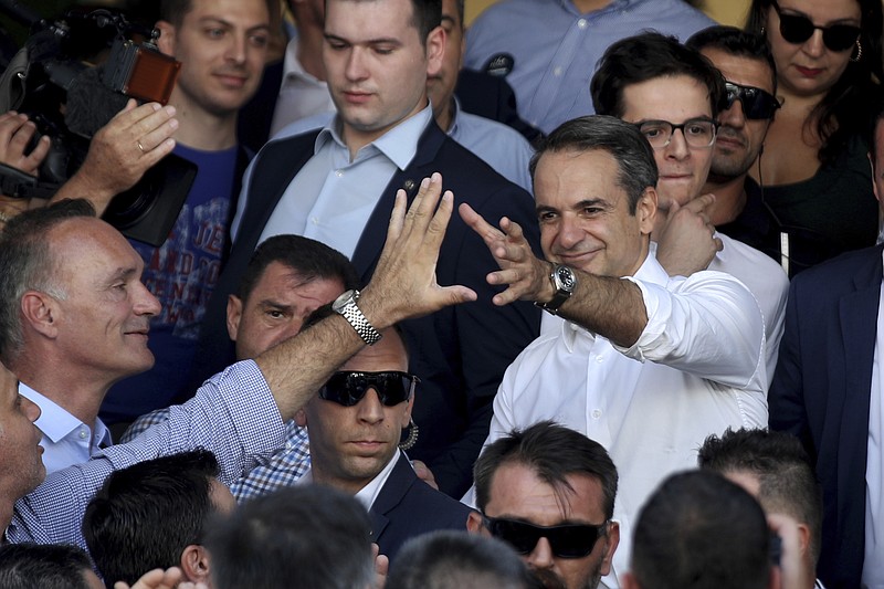 Greek opposition New Democracy conservative party leader Kyriakos Mitsotakis waves his supporters after casts his ballot at a polling station in Athens, on Sunday, July 7, 2019. Greeks are voting in the first parliamentary election since their country emerged from three successive international bailouts but is still struggling to emerge from a crippling nearly decade-long financial crisis. (AP Photo/Petros Giannakouris)