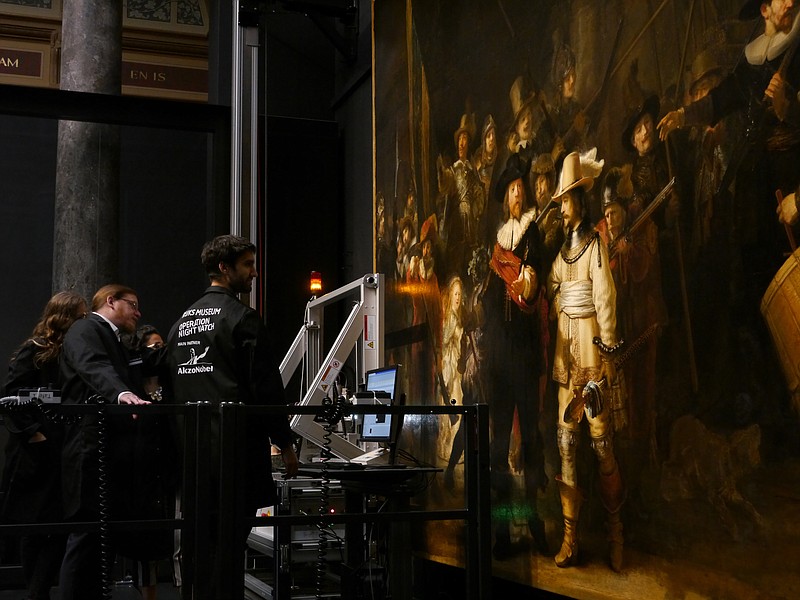 Technicians and researchers check equipment set up inside a glass chamber as they begin to study Rembrandt's 'Night Watch' masterpiece, at the Rijksmuseum in Amsterdam, Monday July 8, 2019. Researchers and restorers at Amsterdam's Rijksmuseum launched a months-long project Monday, using high-tech imaging technology to throw new light on Rembrandt van Rijn's iconic "Night Watch."(AP Photo/Aleksandar Furtula)