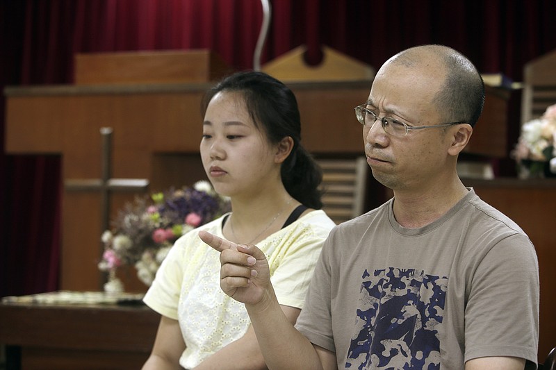 In this Sunday, July 7, 2019, photo, Liao Qiang, right, and his daughter Ren Ruiting speak during an interview with The Associated Press at a church in Taipei, Taiwan. Liao arrived in Taiwan last week after fleeing China with five family members. They plan to seek asylum in the United States. (AP Photo/Chiang Ying-ying)