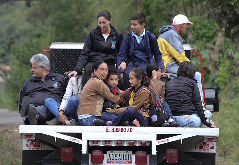 In this June 19, 2019 photo, residents of a remote community catch a ride on the bed of a truck near La Grita, Venezuela. As oil production in the South American country has collapsed under years of mismanagement and U.S. sanctions, many in the industry are confronting another hardship: Fuel shortages. (AP Photo/Rafael Urdaneta)