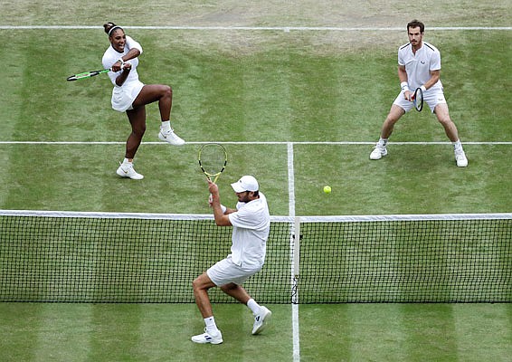 Fabrice Martin avoids a return by Serena Williams as her mixed doubles partner Andy Murray watches during a match Tuesday at Wimbledon in London.
