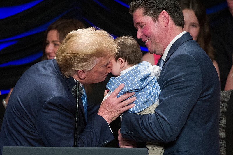 President Donald Trump kisses Hudson Nash, being held by father Andrew Nash, as Trump speaks about kidney health at the Ronald Reagan Building and International Trade Center, Wednesday, July 10, 2019, in Washington. (AP Photo/Alex Brandon)