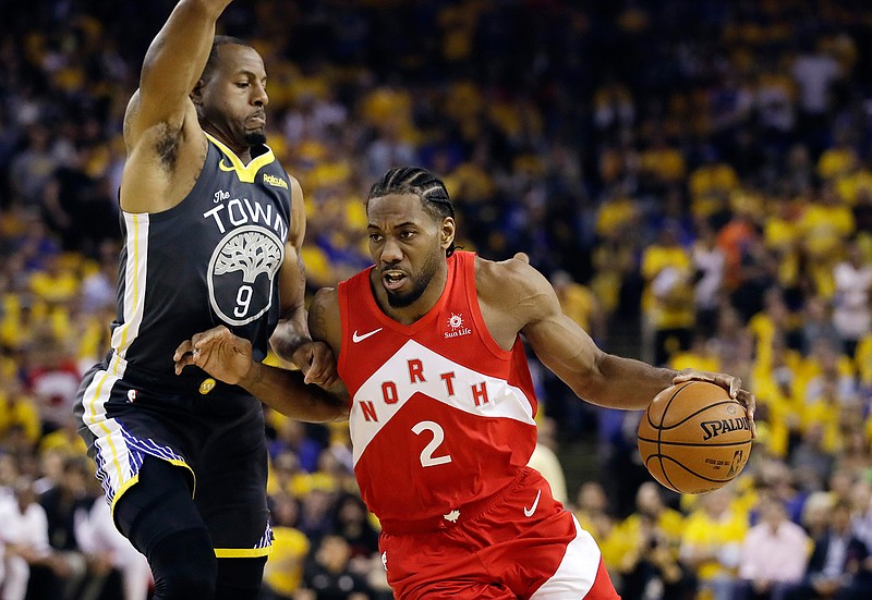 In this June 13, 2019, file photo, Toronto Raptors forward Kawhi Leonard (2) drives against Golden State Warriors forward Andre Iguodala (9) during the first half of Game 6 of basketball's NBA Finals in Oakland, Calif. A person familiar with the negotiations says the Los Angeles Clippers will be landing Kawhi Leonard as a free agent after they acquire Paul George from the Oklahoma City Thunder in a massive trade for players and draft picks. (AP Photo/Ben Margot, File)