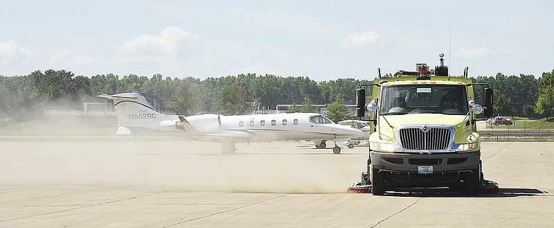 Several planes have once again returned to the facilities at Jefferson City Memorial Airport. A driver from Columbia Regional Airport operating a heavy street brush makes one of numerous passes Thursday to remove the remaining dried mud on the tarmac at the Jefferson City airport. Columbia's airport has provided manpower and equipment to assist in the local airport's cleanup after the second round of flooding. The tarmac is now open for airplane parking and at least one runway is open for takeoff and landing.