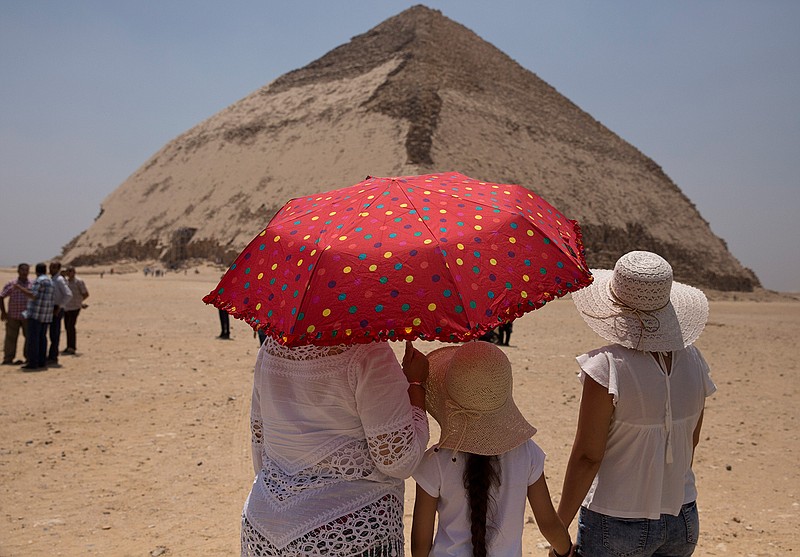 Women visit the Bent Pyramid during an during an event opening the pyramid and its satellites for visitors in Dashur, Egypt, Saturday, July 13, 2019. The Bent pyramid, listed on UNESCO's world heritage list as part of the Memphis necropolis, is considered a transition phase in pyramids construction that comes between step pyramids and complete pyramids. (AP Photo/Maya Alleruzzo)