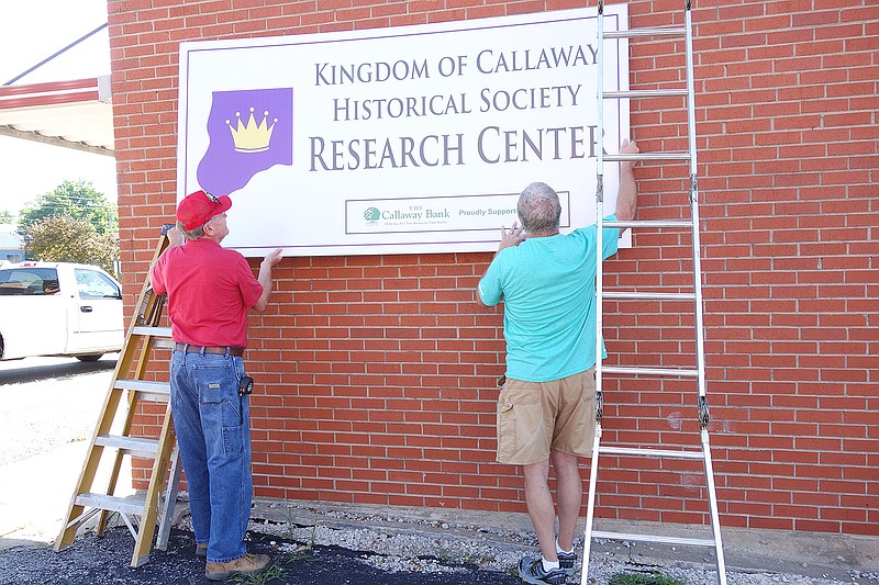 Kingdom of Callaway Historical Society Board President Mike Auer, left, and board member Bryant Liddle work to position the sign for the new Kingdom of Callaway Historical Society Research Center. The facility is at 106 E. Fourth St.
