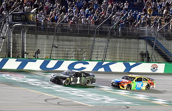 Kurt Busch (1) crosses the finish line ahead of Kyle Busch (18) to win the NASCAR Cup Series race Saturday night at Kentucky Speedway in Sparta, Ky.