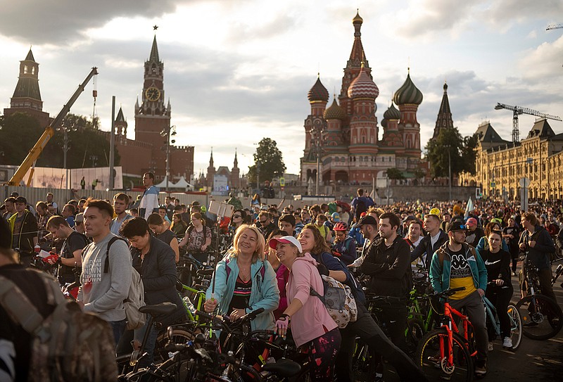 Cyclists wait for the start of cycling during a sunset with Red Square in the background in Moscow, Russia, Saturday, July 13, 2019. (AP Photo/Alexander Zemlianichenko)